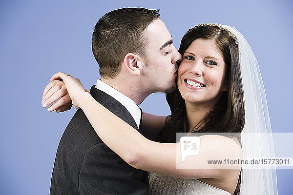 Ein Bräutigam küsst seine Braut.