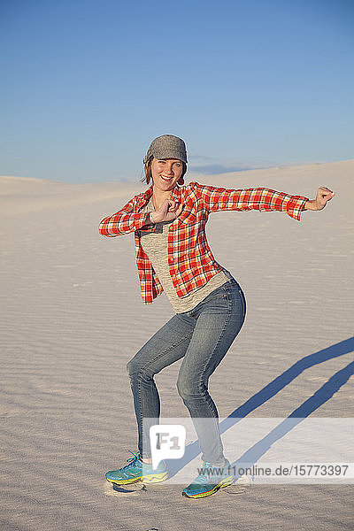 Carefree young woman on the white sand with blue sky White Sands National Monument; Alamogordo New Mexico United States of America