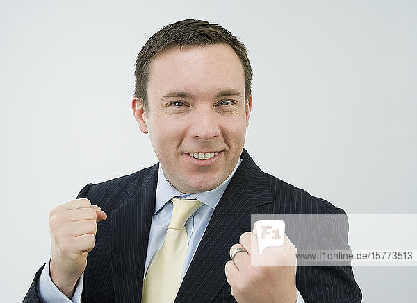 Porträt eines Geschäftsmannes  der seine Fäuste ballt und lächelt