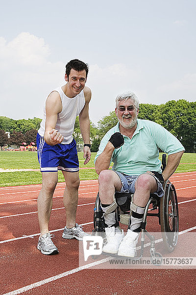 Portrait of a handicapped senior man and a young man smiling.