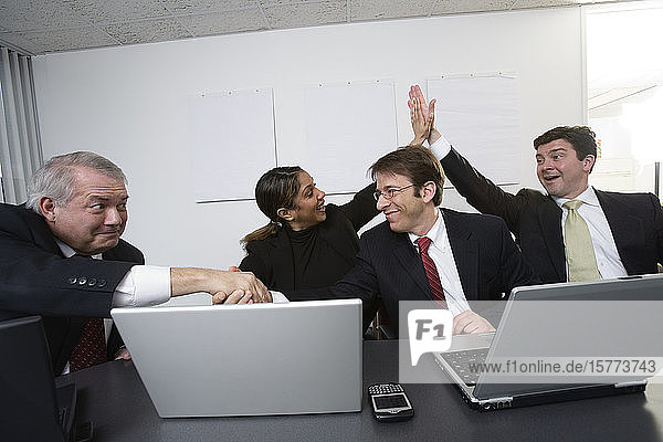 Blick auf feiernde Geschäftsleute in einem Büro.