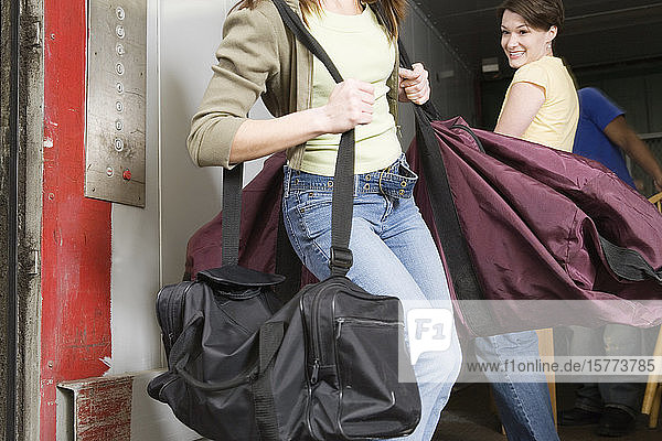 Young woman carrying a huge traveling bag.