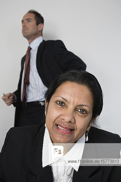 Porträt einer Geschäftsfrau  hinter der ein Architekt steht.