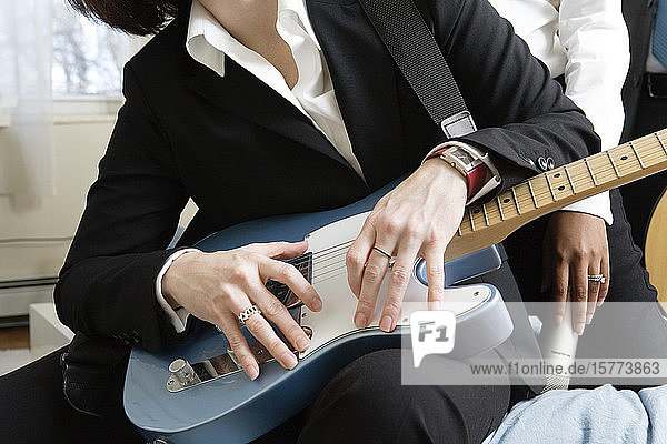 Midsection of a woman holding guitar.
