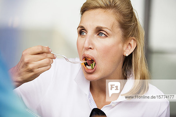 View of a woman eating meal.