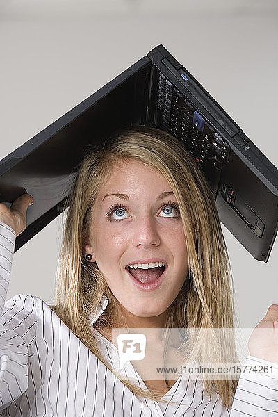 A woman with a laptop over her head.