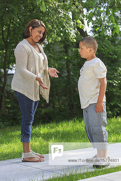 Mother talking to pre-teen son on an outdoor path
