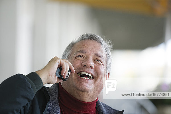 A business man conversing on a mobile phone.