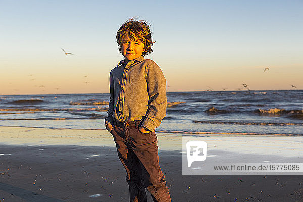 Ein Junge und ein Möwenschwarm an einem Strand