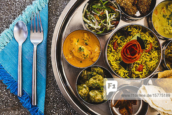 Nahaufnahme eines traditionellen indischen Mittagessens mit Reis  verschiedenen Currys  Essiggurken und Gemüse aus der Vogelperspektive.