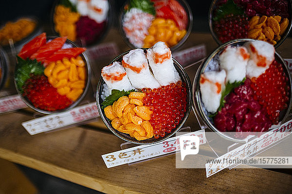 Hochwinkel-Nahaufnahme von Plastikschüsseln mit japanischem Essen  die vor einem Restaurant ausgestellt sind.