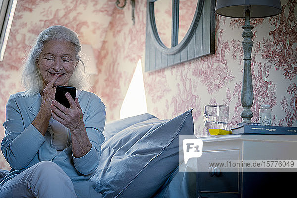 Ältere Frau schaut auf ihr Smartphone