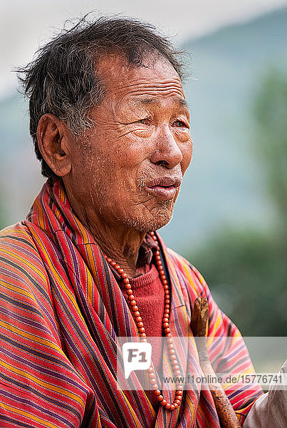Portrait elderly Bhutanese man wearing prayer beads Bhutan Asia