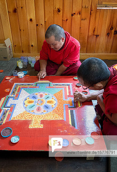 Buddhist monks making a diorama (mandala) with coloured sand which once made is wiped off to demonstrate transience and impermanence Bhutan Asia