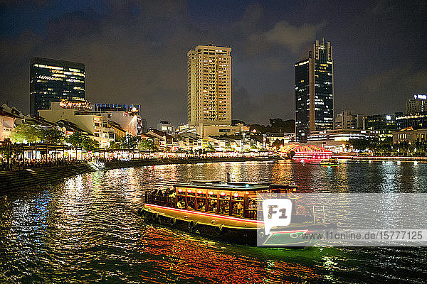 Tourist boat near the historic Boat Quay in Singapore river at dusk Singapore Southeast Asia Asia