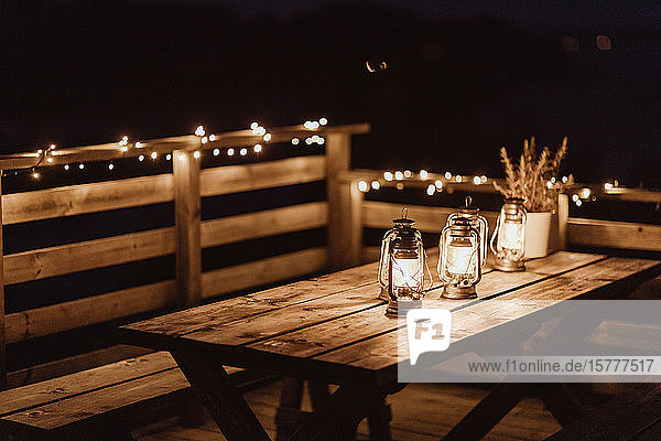 Beleuchtete Laternen auf leerem Tisch im Restaurant während der Nacht