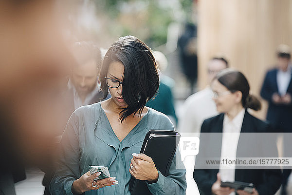 Unternehmerin benutzt Smartphone vor dem Büro