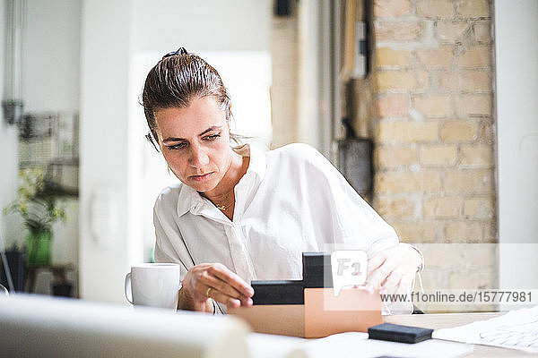 Designerin  die mit Boxen arbeitet  während sie im Heimbüro sitzt