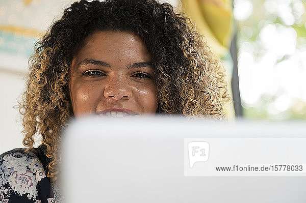 Smiling woman behind laptop