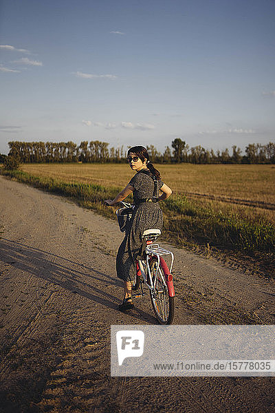 Woman riding bicycle on country road