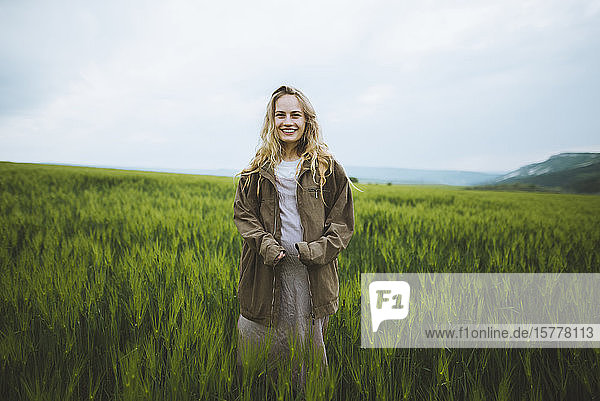 Smiling woman wearing jacket in field in Crimea Ukraine