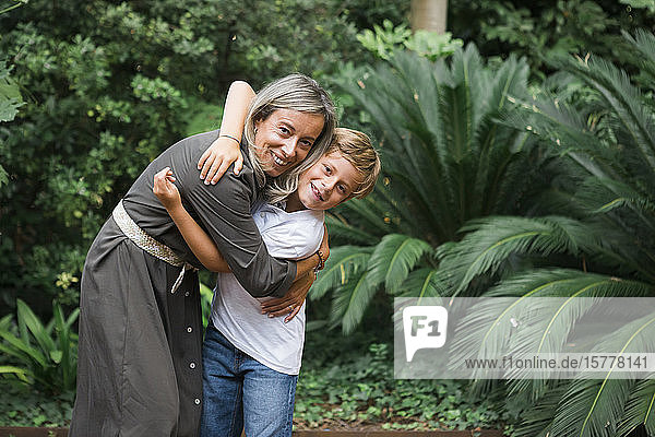 Mutter und Sohn umarmen sich am Busch