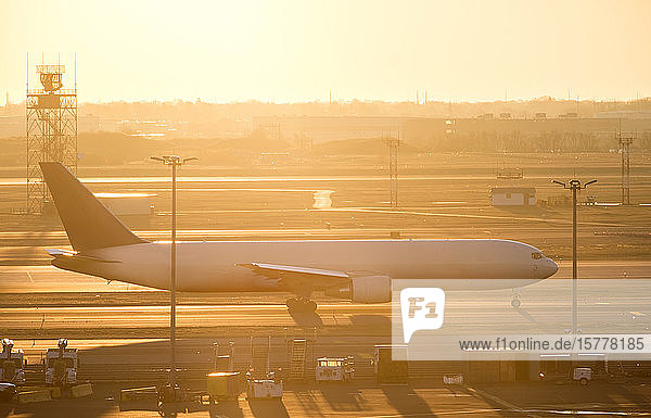 Airplane on runway at sunset
