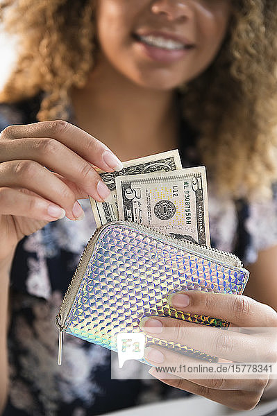 Lächelnde Frau hält Brieftasche mit Geld