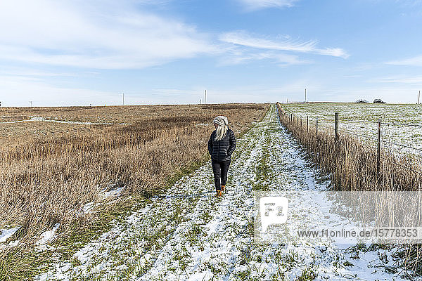 Woman walking in snowy field