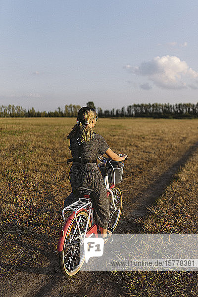 Frau fährt Fahrrad in einem Feld