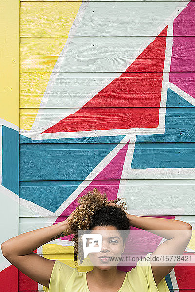 Woman posing against colorful wall