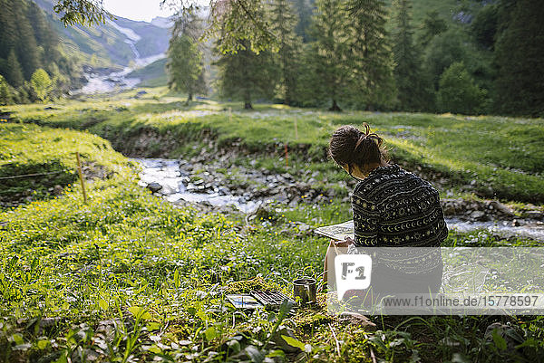 Frau malt mit Aquarellfarben am Fluss in Appenzell  Schweiz