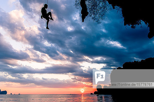 Bergsteiger bei Sonnenuntergang über dem Meer schwebend Tonsai Krabi Thailand