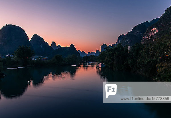Sonnenuntergang über dem Fluss und dem Guilin-Zuckerhut Yangshuo Guangxi China