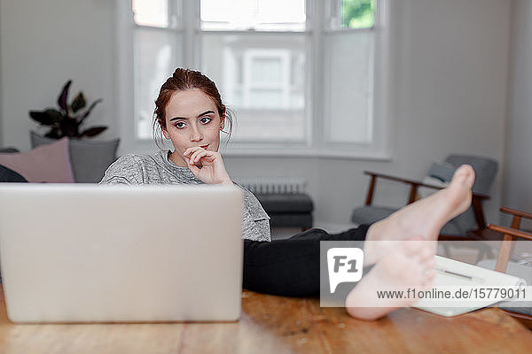 Woman using laptop on dining table