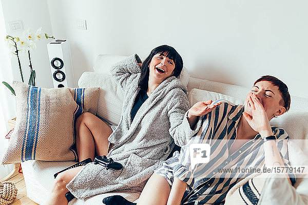 Frauen in Nachtwäsche entspannen sich auf dem Sofa  lachen