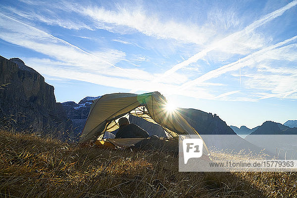 Wanderer erwacht im Zelt auf dem Berggipfel  Canazei  Trentino-Südtirol  Italien