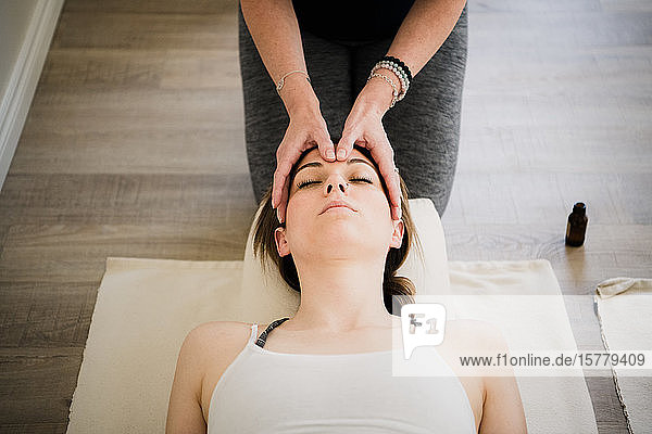 Frau genießt Kopfmassage im Yoga-Retreat