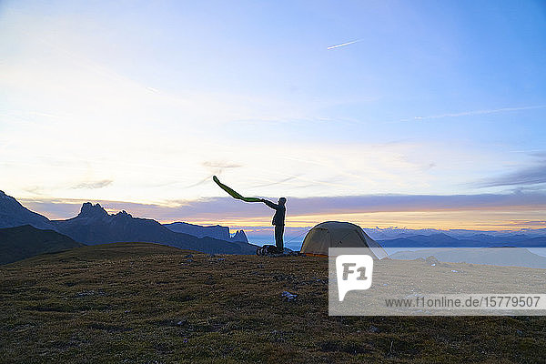 Wanderer  der sich auf ein Lager bei Sonnenuntergang vorbereitet  Canazei  Trentino-Südtirol  Italien