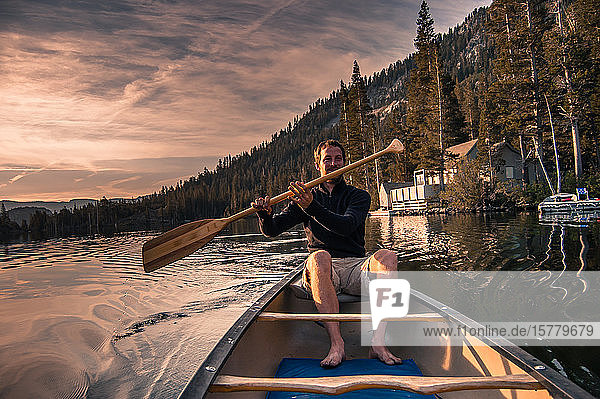 Young man canoeing on Echo Lake High Sierras California USA
