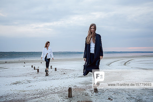 Frauen balancieren auf Holzstümpfen am Strand  Odessa  Ukraine