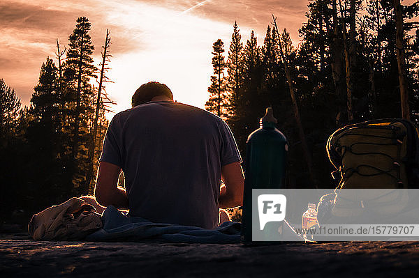 Junger männlicher Wanderer der bei Sonnenuntergang eine Pause macht Tuolumne Meadows oberer Teil des Yosemite Nationalparks Kalifornien USA