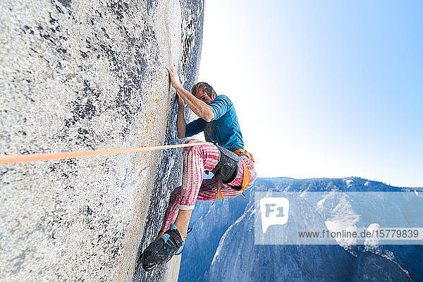 Tiefblick auf einen Bergsteiger der die steile Wand von The Nose El Capitan Yosemite National Park hinaufklettert.