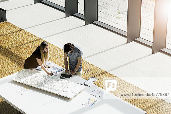 High angle view of two young architects working on an architectural model.