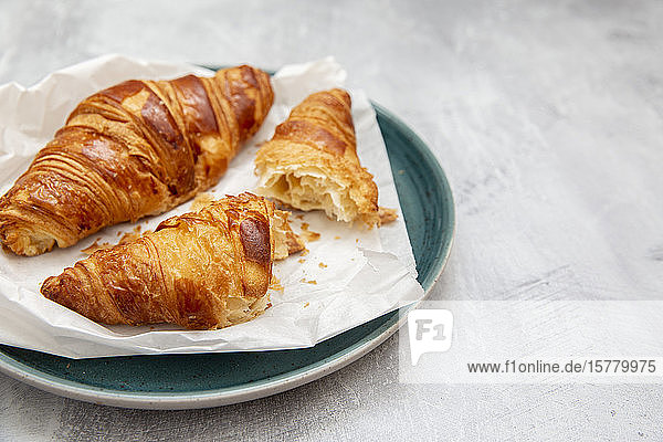 Plate of croissants whole and broken in half