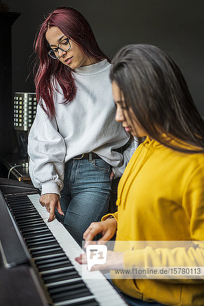 Zwei Mädchen im Teenageralter üben Klavier