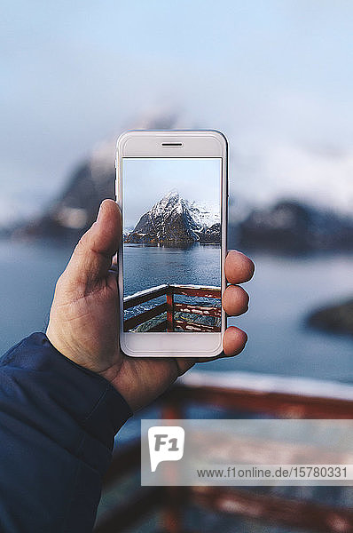 Nahaufnahme eines Touristen bei der Aufnahme eines Smartphone-Fotos auf Hamnoy  Lofoten  Norwegen