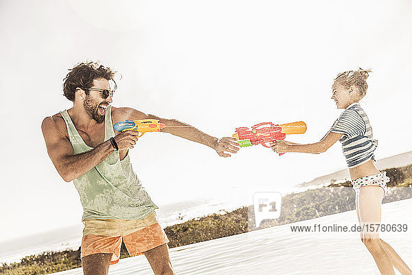 Father and daughter having a water fight