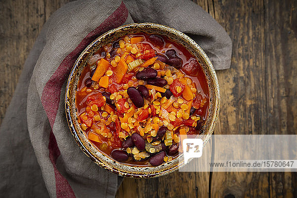 Schale mit veganem Chili mit roten Linsen Selleriestangen Kidneybohnen Tomaten und Karotten