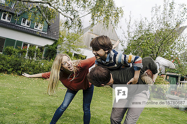 Happy family playing in garden  pretending to fly